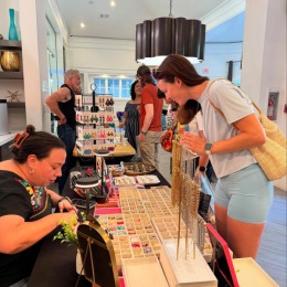 Your new community awaits! a woman looks at a table full of jewelry in a lobby