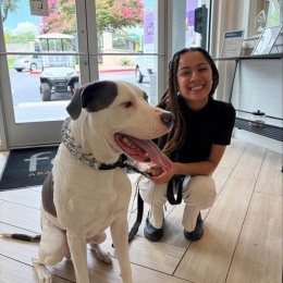We love our furry friends! a woman crouching next to a dog smiling
