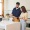 a man in a kitchen holding a clipboard next to a woman